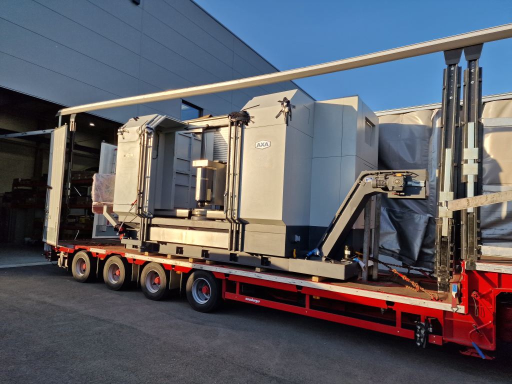 Große CNC-Fräsmaschine auf Transportwagen vor moderner Fabrik.